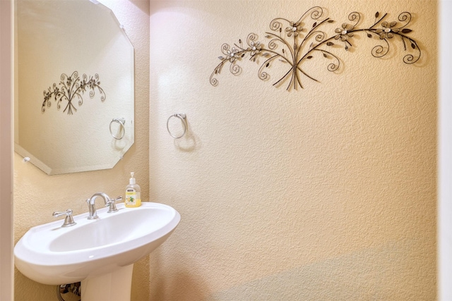 bathroom with a textured wall and a sink