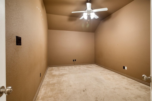 carpeted spare room with a textured wall, lofted ceiling, ceiling fan, and baseboards