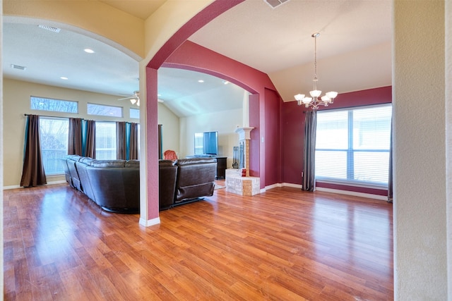 living room featuring lofted ceiling, light wood-style floors, plenty of natural light, and visible vents