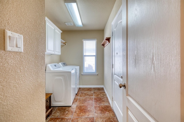 washroom featuring a textured ceiling, visible vents, cabinet space, tile patterned floors, and washing machine and clothes dryer