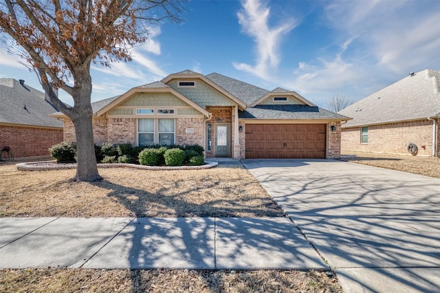 craftsman inspired home with an attached garage, brick siding, concrete driveway, and roof with shingles