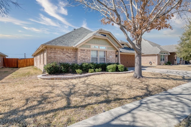 view of front of house with a garage, driveway, a shingled roof, fence, and brick siding