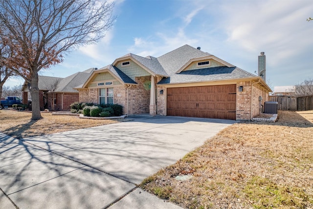 view of front facade with an attached garage, central air condition unit, brick siding, fence, and concrete driveway