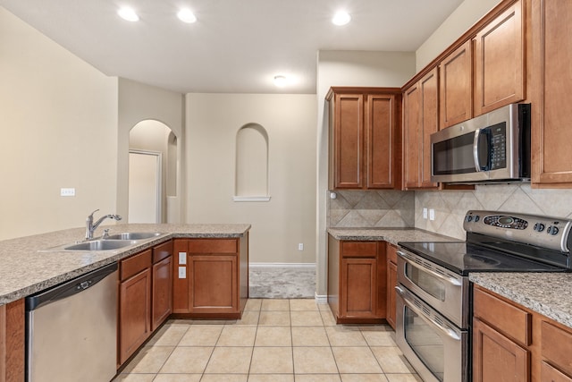 kitchen with decorative backsplash, appliances with stainless steel finishes, light countertops, and a sink