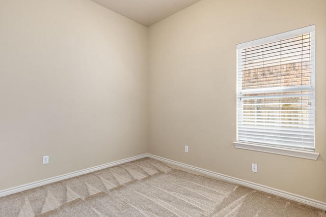 spare room featuring carpet floors and baseboards