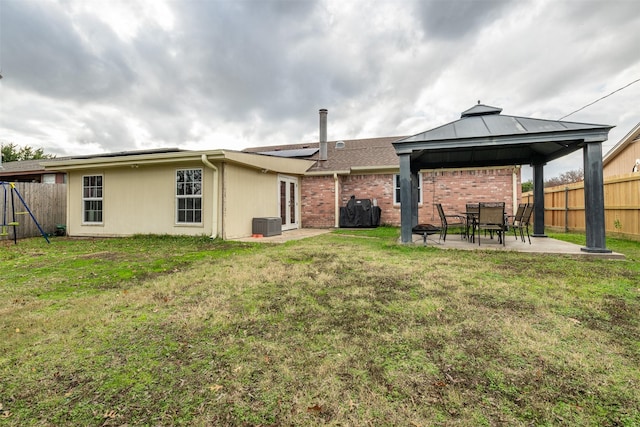 back of house featuring a patio area, a fenced backyard, a lawn, and a gazebo