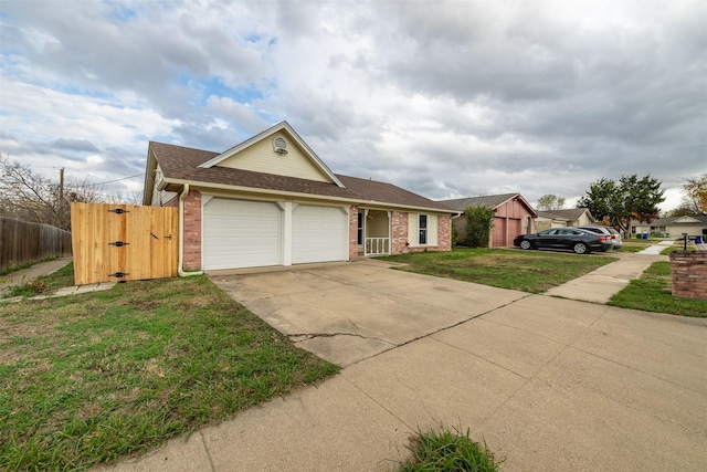 view of front facade featuring brick siding, a front yard, fence, a garage, and driveway