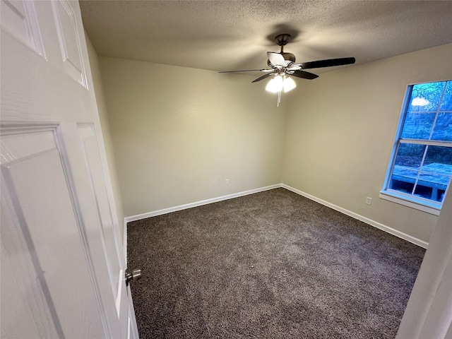 unfurnished room with a textured ceiling, ceiling fan, dark carpet, and baseboards