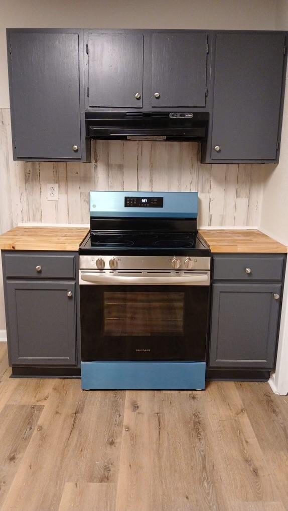 kitchen featuring under cabinet range hood, butcher block counters, electric stove, gray cabinets, and light wood finished floors