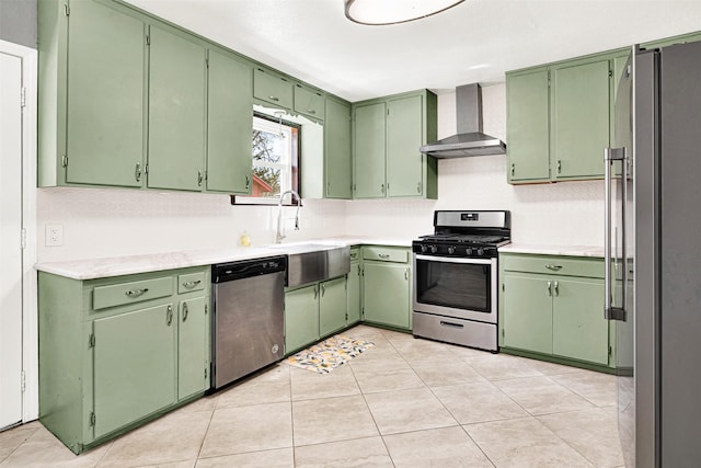 kitchen with light countertops, appliances with stainless steel finishes, light tile patterned flooring, a sink, and wall chimney exhaust hood