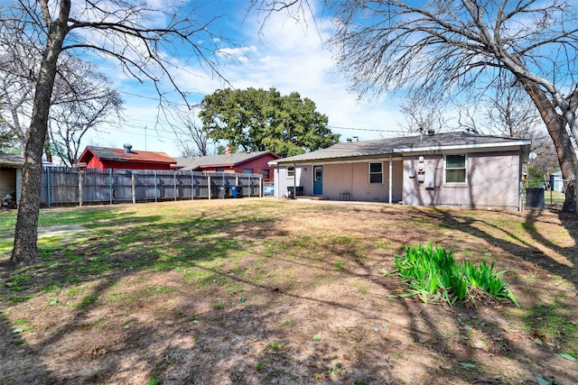 rear view of property with fence and a yard