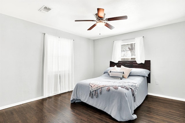 bedroom featuring visible vents, ceiling fan, baseboards, and wood finished floors