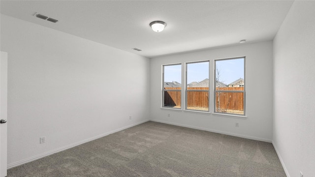 spare room with baseboards, visible vents, and carpet flooring