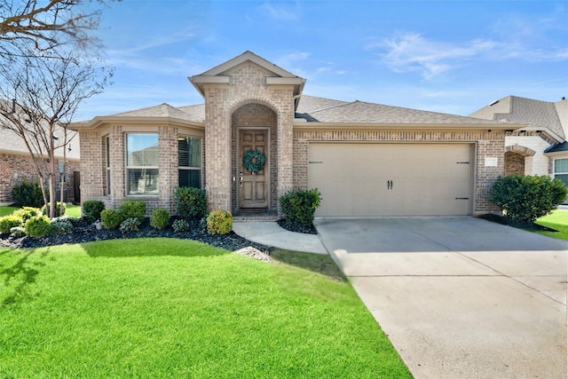 french country inspired facade with an attached garage, brick siding, a shingled roof, driveway, and a front lawn