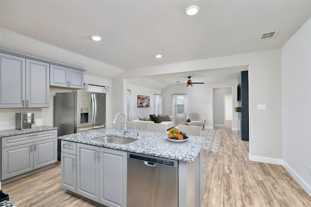 kitchen featuring gray cabinetry, a sink, visible vents, open floor plan, and appliances with stainless steel finishes