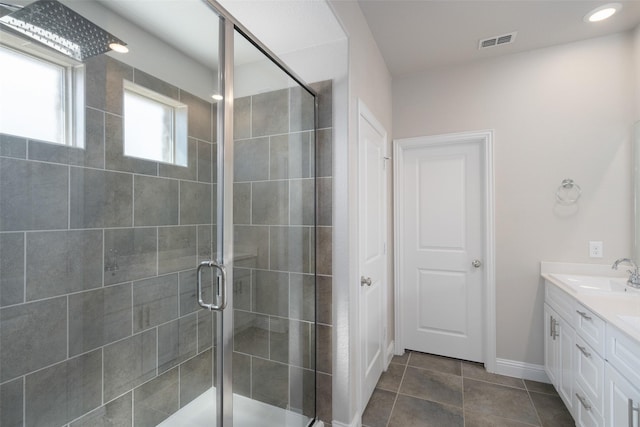 full bathroom featuring vanity, baseboards, visible vents, a shower stall, and tile patterned floors