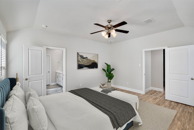 bedroom featuring lofted ceiling, light wood-style flooring, visible vents, and baseboards