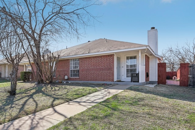 ranch-style home with brick siding, a chimney, and a front lawn