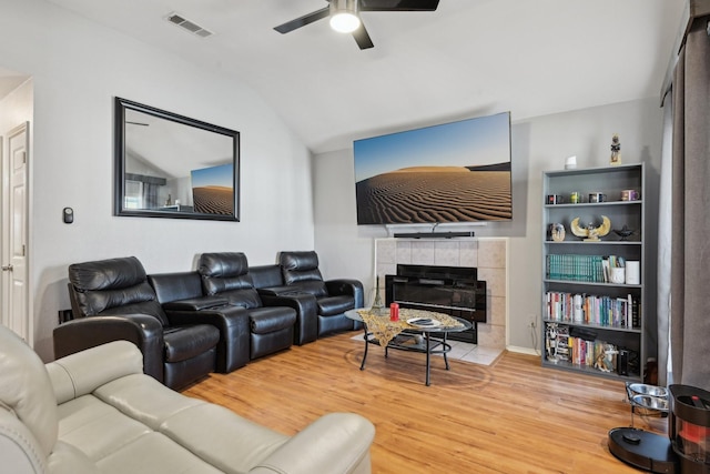 living room featuring visible vents, ceiling fan, wood finished floors, vaulted ceiling, and a fireplace