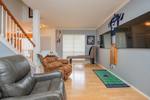 living area with stairs, ornamental molding, a wealth of natural light, and wood finished floors