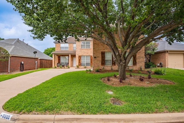 view of front of home featuring driveway, brick siding, and a front yard