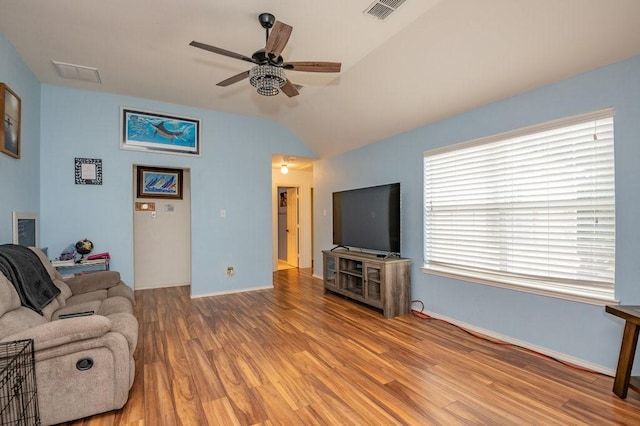 living room featuring baseboards, light wood finished floors, visible vents, and a ceiling fan