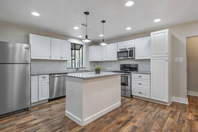 kitchen featuring a center island, dark wood finished floors, stainless steel appliances, visible vents, and a sink