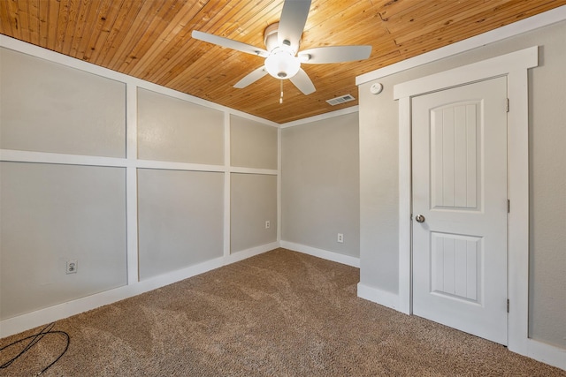 unfurnished bedroom featuring visible vents, carpet, wood ceiling, and a ceiling fan