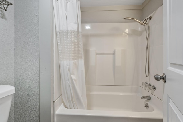 full bathroom featuring toilet, shower / bathtub combination with curtain, and a textured wall