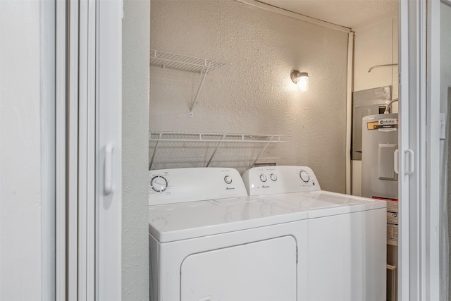 washroom with a textured wall, water heater, and independent washer and dryer