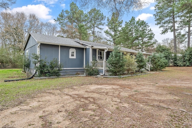 view of front of property featuring covered porch and a shingled roof