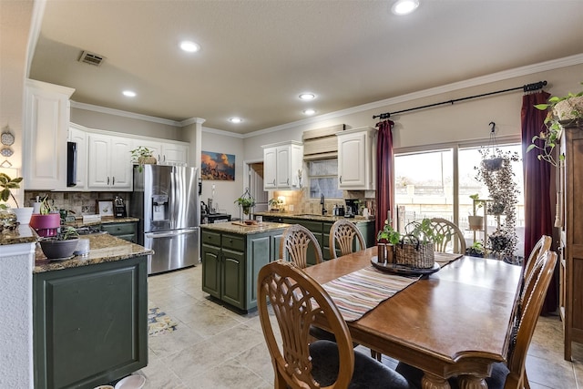 kitchen with crown molding, tasteful backsplash, white cabinets, and stainless steel fridge with ice dispenser