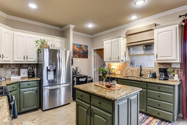 kitchen featuring green cabinets, stainless steel appliances, a sink, and white cabinets