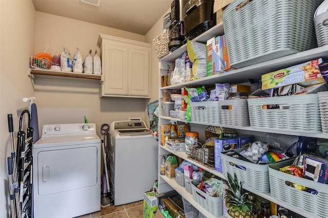 laundry area featuring washing machine and dryer, visible vents, and light tile patterned flooring