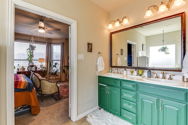 ensuite bathroom featuring double vanity, ensuite bath, ceiling fan, and a sink