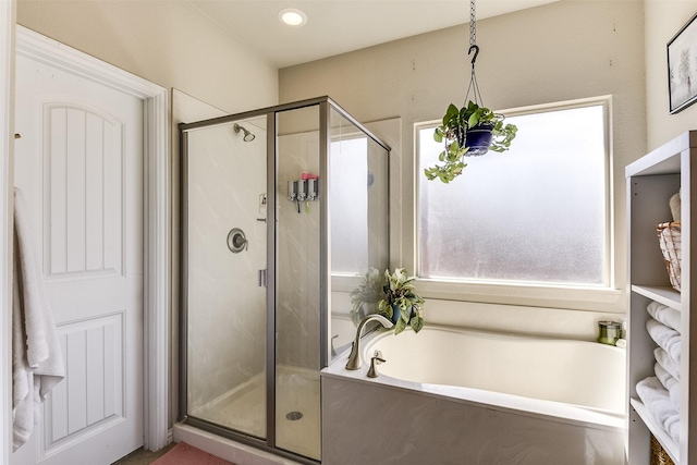 bathroom featuring a stall shower and a bath