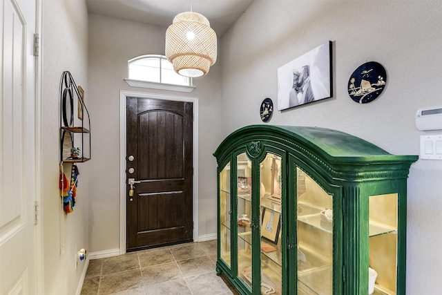 foyer with baseboards and tile patterned floors