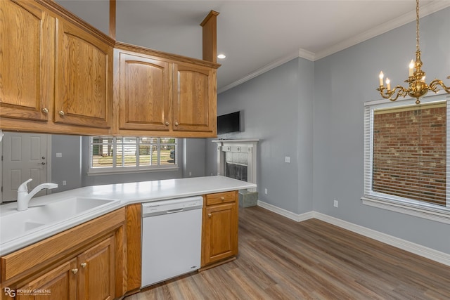 kitchen with white dishwasher, wood finished floors, a sink, baseboards, and ornamental molding