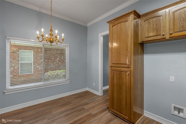 interior space with a chandelier, wood finished floors, baseboards, brown cabinets, and crown molding