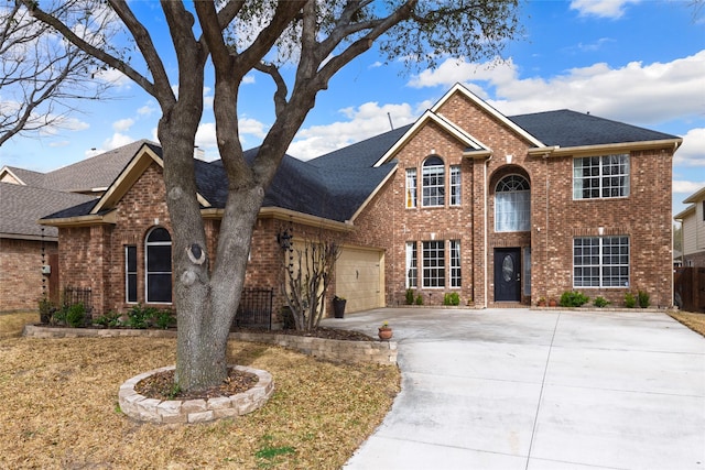 traditional-style house featuring brick siding, roof with shingles, and driveway