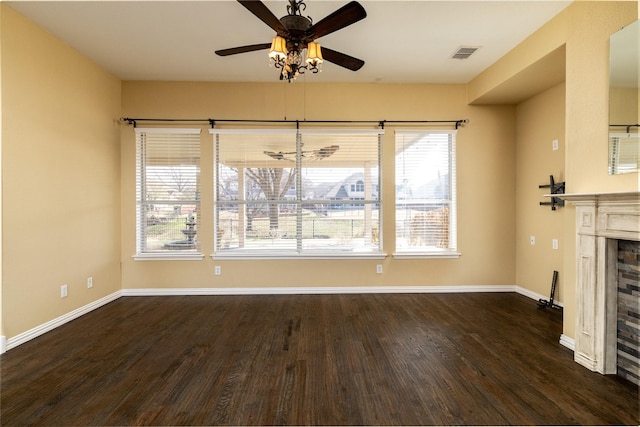 unfurnished living room with visible vents, baseboards, ceiling fan, and dark wood-style flooring