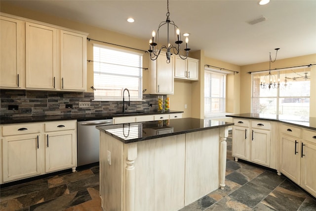 kitchen with visible vents, a chandelier, dishwasher, stone tile flooring, and a sink