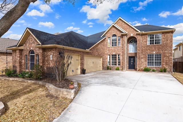 view of front of home featuring a garage, fence, brick siding, and driveway