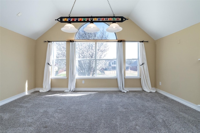 carpeted empty room with baseboards and vaulted ceiling