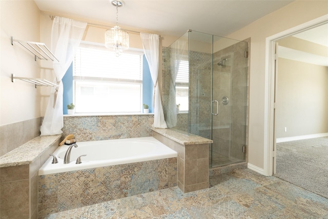 full bathroom with a bath, a stall shower, baseboards, and an inviting chandelier