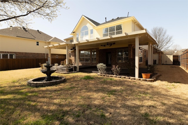 back of house with a patio, a lawn, a fenced backyard, and brick siding