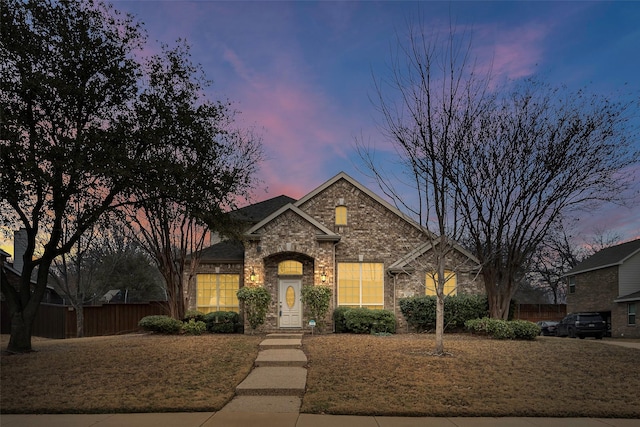 view of front of house with brick siding and fence