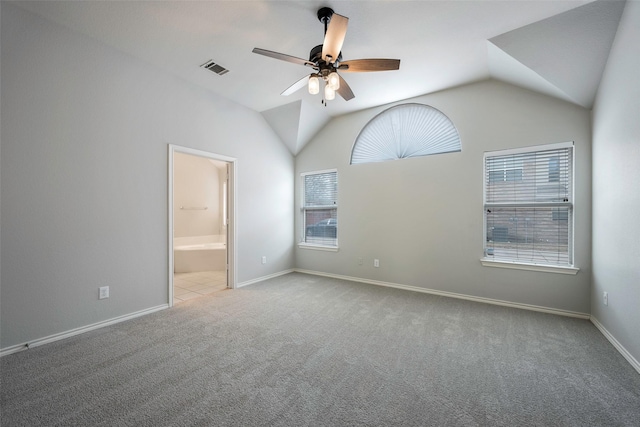 unfurnished room featuring lofted ceiling, carpet flooring, visible vents, a ceiling fan, and baseboards