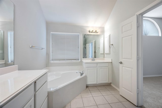 bathroom with tile patterned flooring, a bath, and vanity