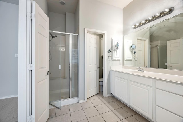 bathroom with tile patterned flooring, toilet, a shower stall, and vanity